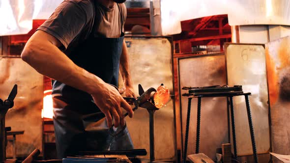 Glassblower shaping a molten glass