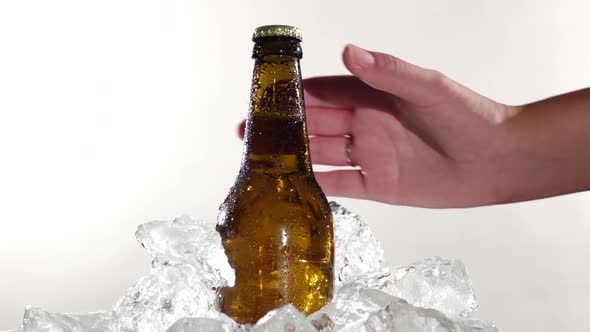 Guy Takes a Bottle of Cold Beer. White Background . Close Up. Slow Motion