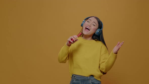 Happy Woman with Headphones Singing at Smartphone