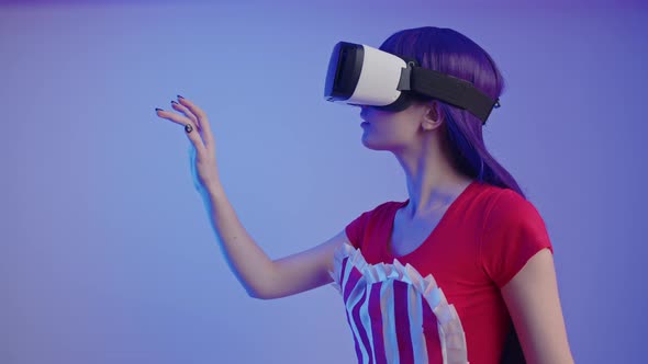 Adored White Girl Gamer in Her 20s Moving Her Fingers in the Air Selecting Items in VR Game