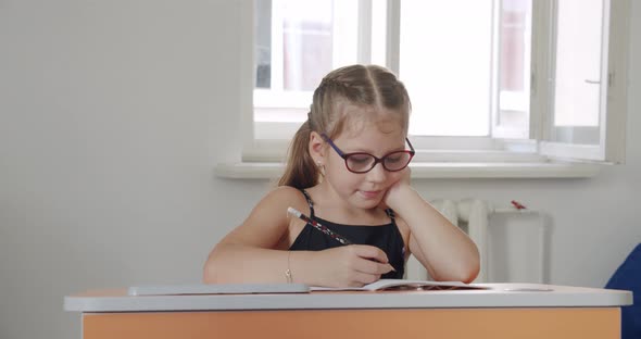 Portrait School Kid Siting on Table Doing Homework School and Home Schooling