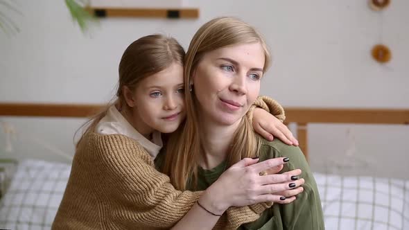 Cute Smiling Child Daughter Hugs Mom Look Away