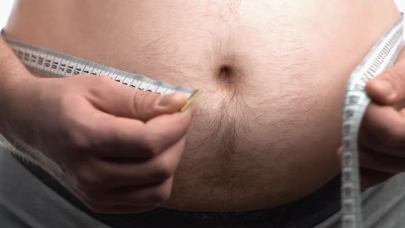 Elderly Fat Man Measures His Waist with a Centimeter