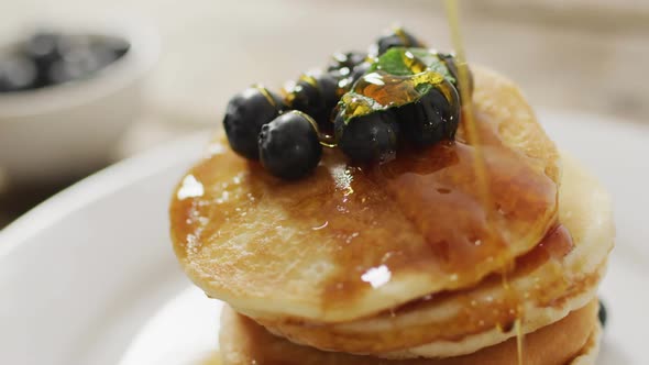 Video of pancakes on plate seen from above on wooden background