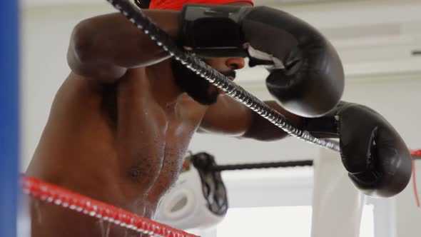 Male boxer relaxing in boxing ring 4k