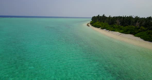 Wide angle birds eye abstract shot of a white paradise beach and blue sea background in colourful 4K