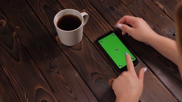 Closeup of a Woman Drinking Coffee and Using a Phone with a Green Screen