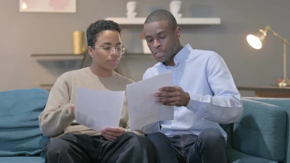 Couple Having Failure While Reading Documents on Sofa