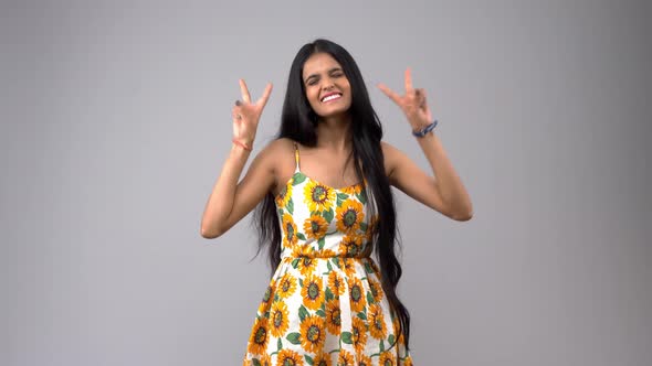 Cheerful Indian girl making a victory sign