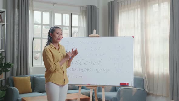 Asian Female Teacher With Marker Pen Teaching Math At Home