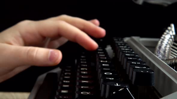 The girl is typing on a retro typewriter.