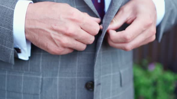 Man Fastens Button on His Jacket Before Wedding Ceremony