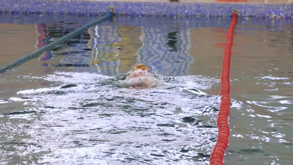 A Man Swimming on the Track in the Pool