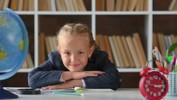 young hispanic schoolgirl primary school student sitting at her desk