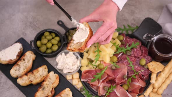 Making Bruschetta  Woman Smearing Cream Cheese on a Grilled Baguette