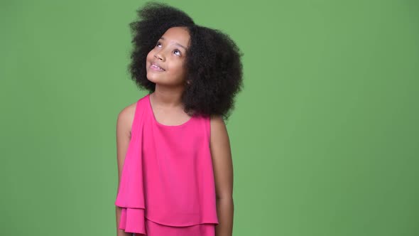 Young Cute African Girl with Afro Hair Thinking While Looking Up