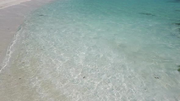 Daytime overhead island view of a summer white paradise sand beach and blue sea background in colour