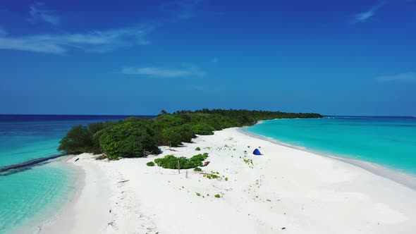 Beautiful fly over travel shot of a summer white paradise sand beach and blue water background in 4K