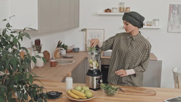 Muslim Woman Putting Ingredients for Smoothie in Blender