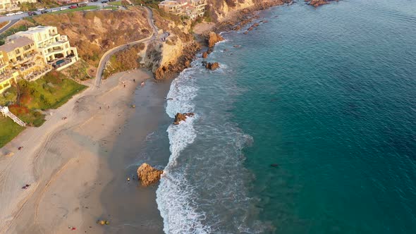 Flying over million dollar beach front luxury homes and the beautiful Laguna Beach California tide p