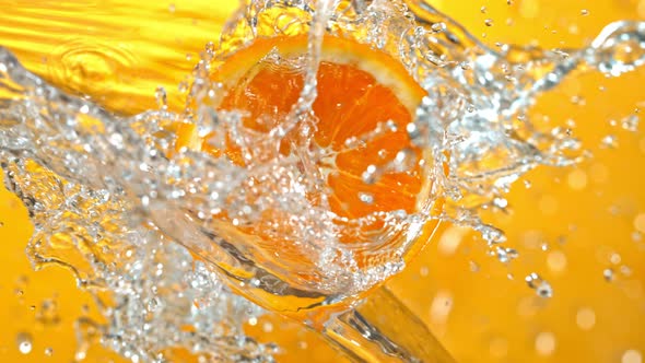 Super Slow Motion Shot of Rotating Fresh Orange Slice and Splashing Water at 1000Fps