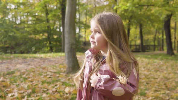 Cute Little Caucasian Girl Disagrees and Shakes Her Head in a Park  Closeup