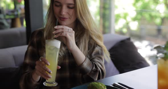 Woman Drinking Cocktail in Restaurant