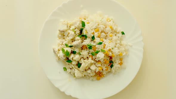 dish with rice, green onions, corn and fish on a plate