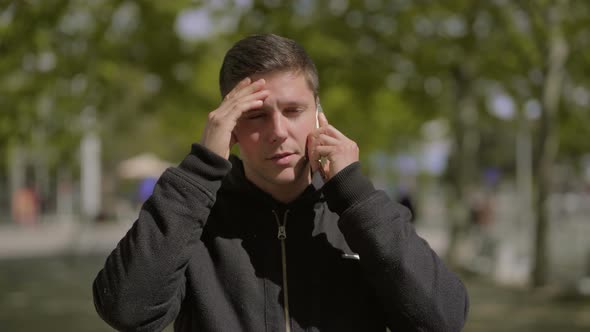 Thoughtful Man Talking By Smartphone Outdoor