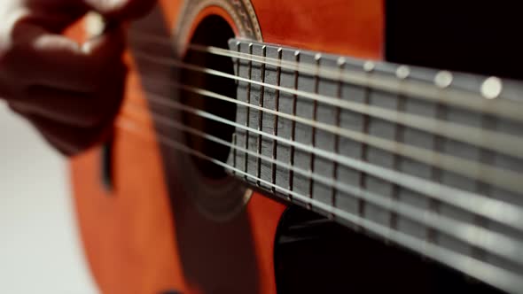 Male Musician Plays Strings of an Acoustic Guitar Playing Music Closeup of Hands