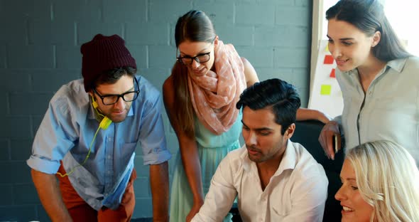 Businesspeople having a discussion while using laptop