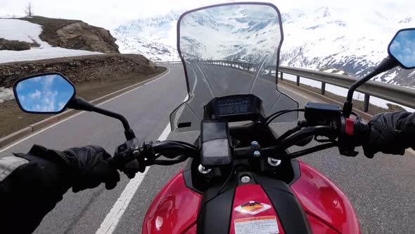 Motorcyclist Rides on Beautiful Landscape Snowy Mountain Road Near Switzerland Alps