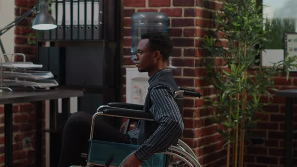 African American Man in Wheelchair Planning Sales Growth on Laptop