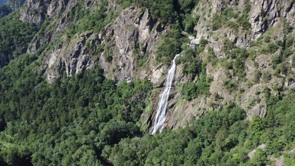 the drone flies past the breathtaking waterfall "Pisse Vache" south into the valley of Valais with s