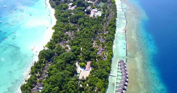 Daytime fly over island view of a sunshine white sandy paradise beach and blue water background in b