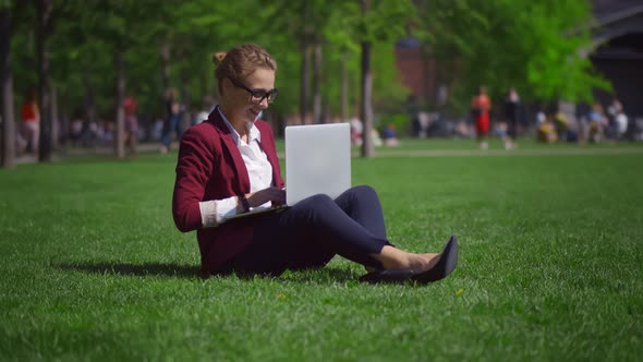 Excited Smiling Businesswoman Celebrating Business Success Raising Hands Looking at Laptop Outdoors