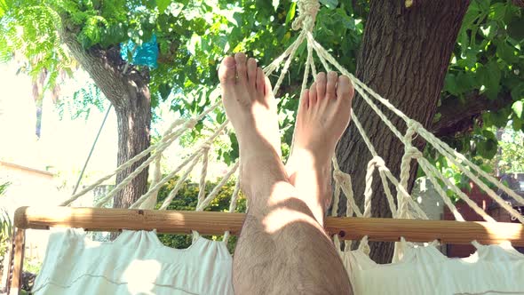 POV Point of View of Man Relaxing on Hammock in a Luxury Resort
