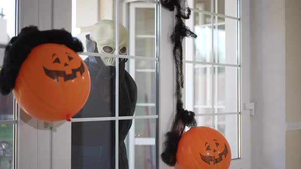 Scary Alien Walking Behind Glass Door Knocking Waving Inviting Outdoors with Halloween Jack O