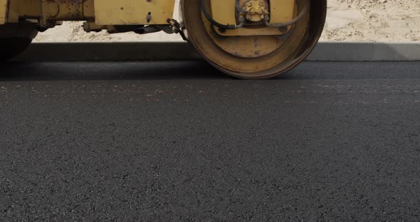 A Large Yellow Steamroller Flatten Hot Asphalt. Builds A New Road