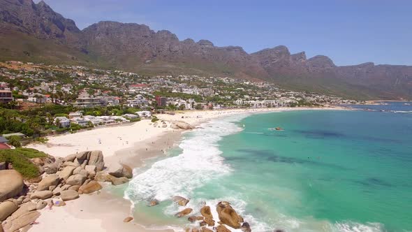 Aerial travel drone view of Camps Bay beach, Cape Town, South Africa.