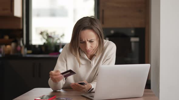 Upset Young Woman Using Online Banking Service Problem with Blocked Credit Card Using Laptop