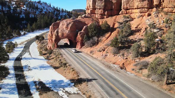 Aerial views of cars passing through the natural Red Canyon arch along Route 12 in the Dixie Nationa