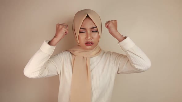 Young Asian Islam woman wearing headscarf is upset and angry.