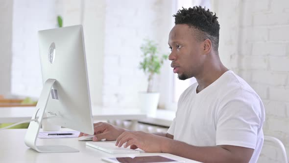 Focused Casual African Man Working on Desktop in Office 