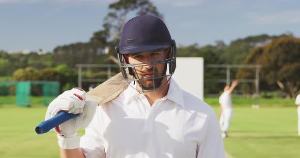 Cricket player with helmet and bat looking at the camera