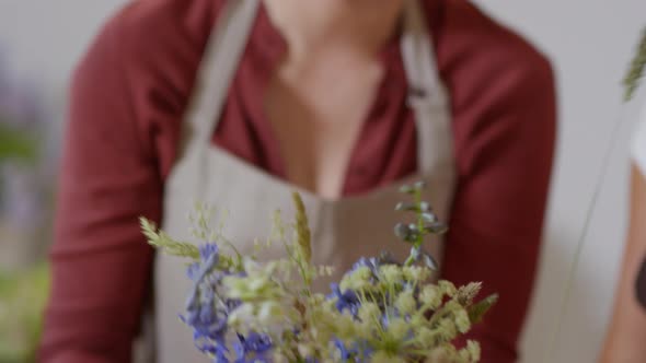 Skilled middle-aged florist composing bouquet