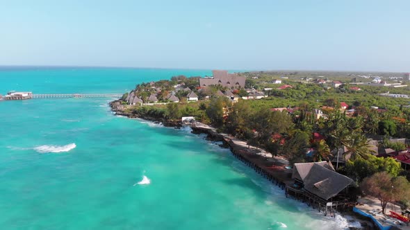 Tropical Landscape of Zanzibar Waves Hit Reef on Hotels Coastline with Palms