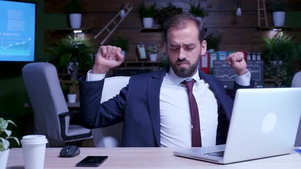 Businessman Tries to Relax Late at Night in the Office