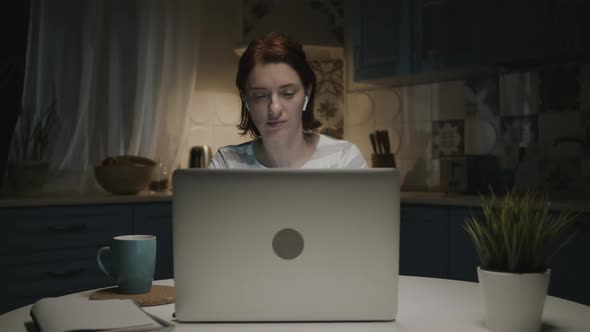 Woman In The Kitchen With Laptop. Woman Tired. Her Head Hurts