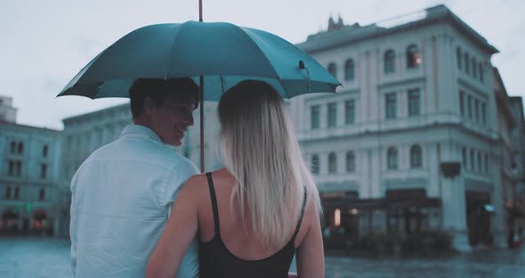 Couple holding umbrella and talking